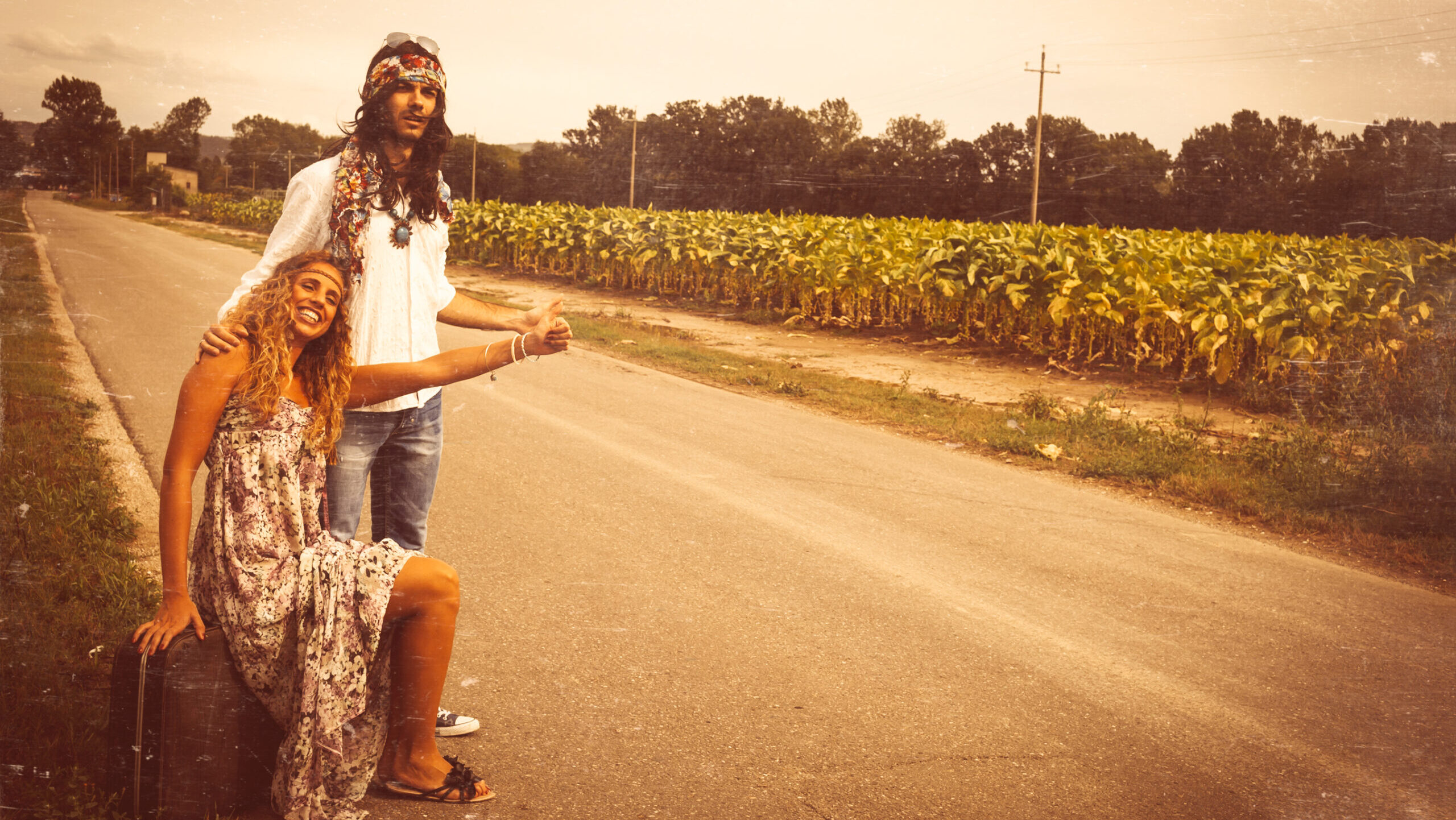 Young adult hippie couple hitchhiking